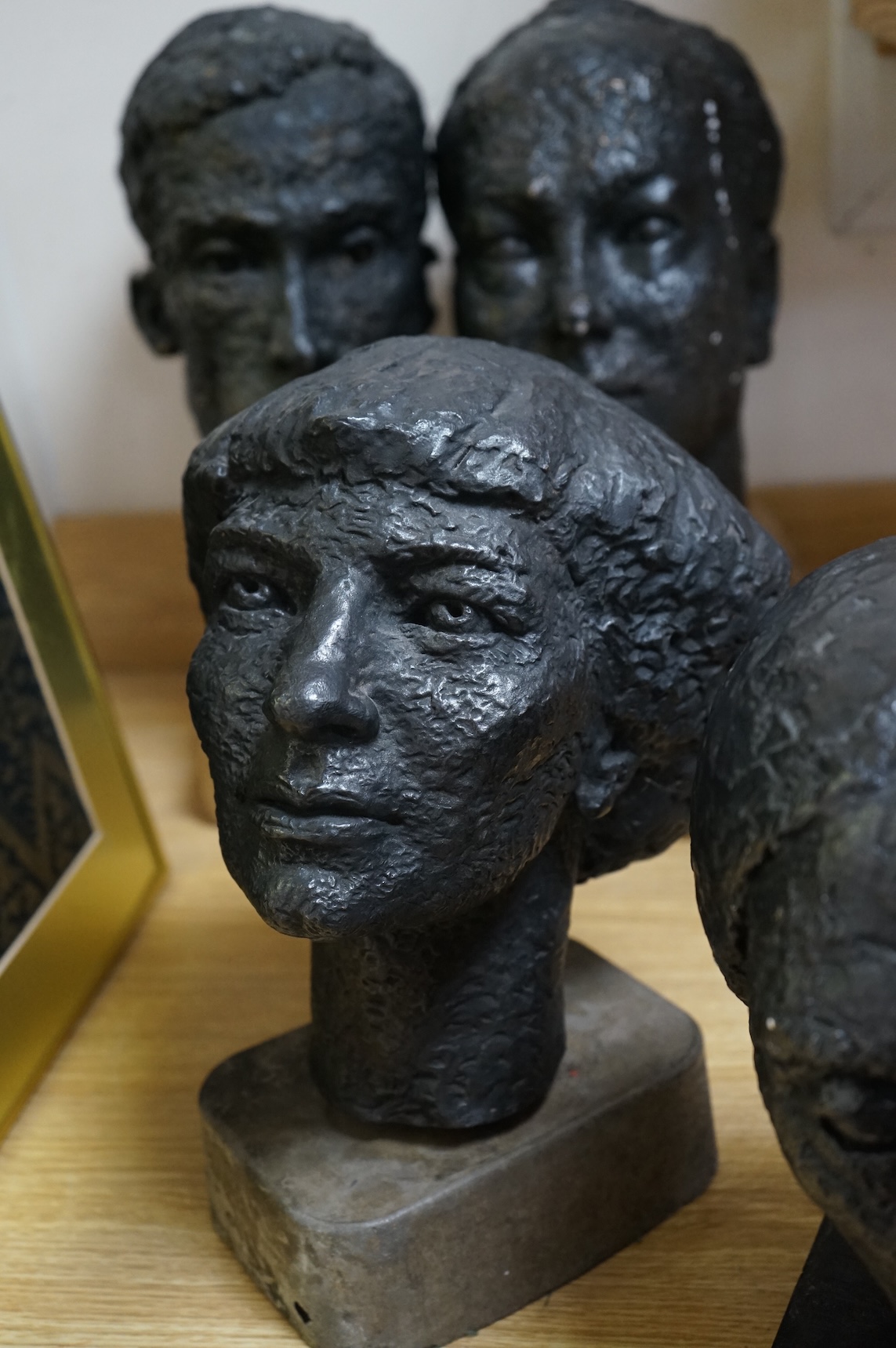Six black painted composition heads, by Hazel Armour, tallest 49cm